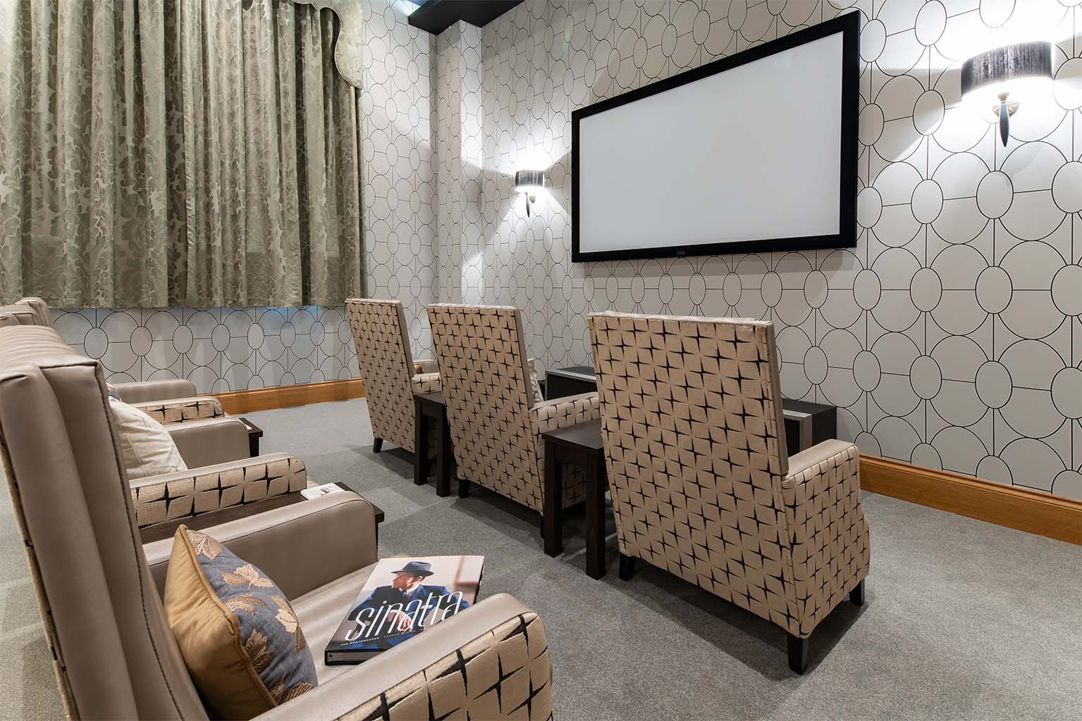 armchairs facing a large screen