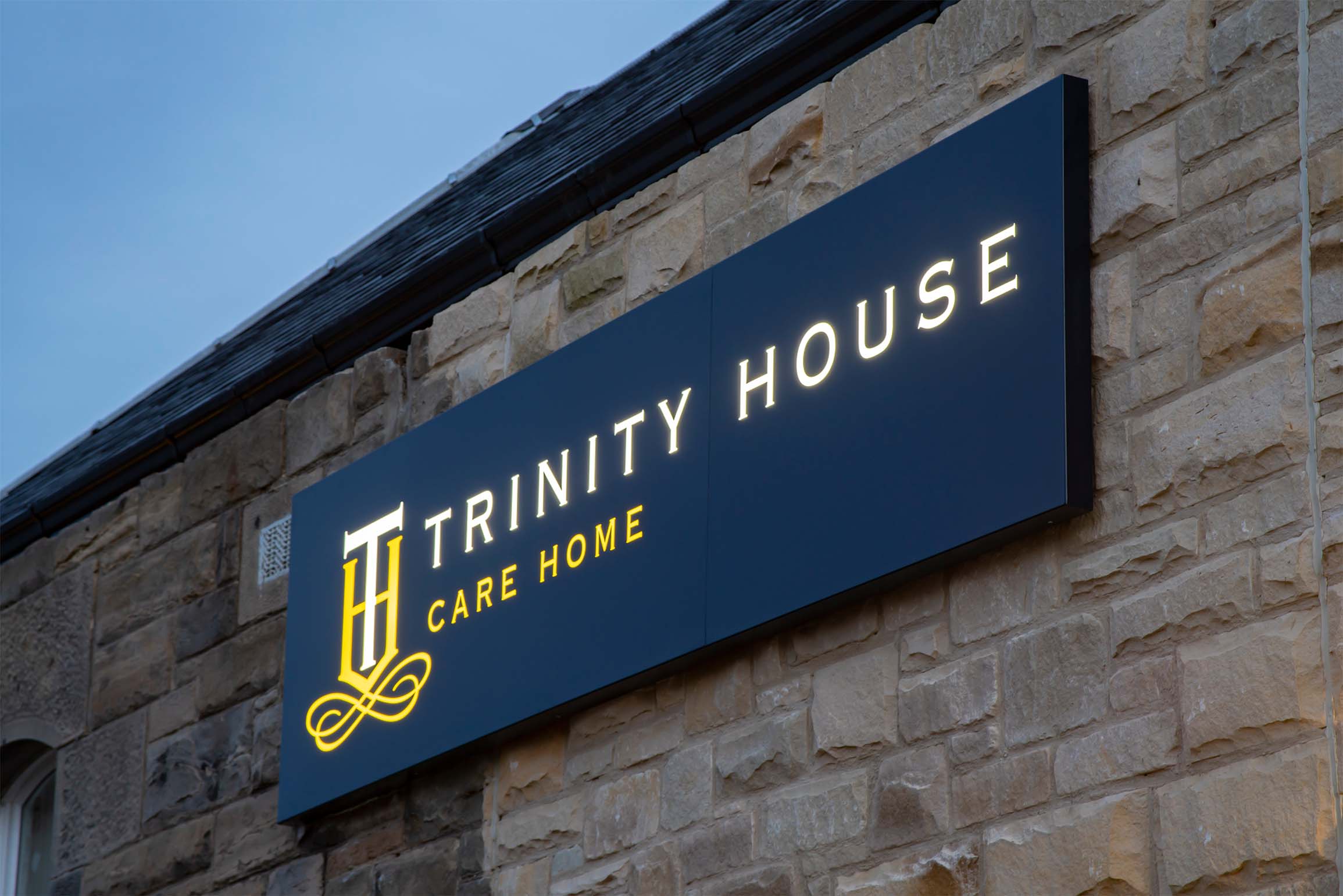 trinity house care home sign lit up at night