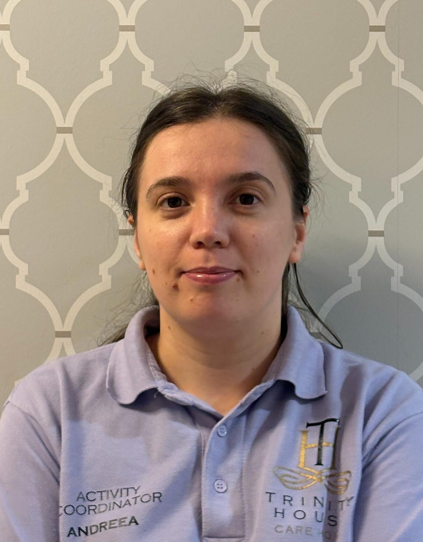 woman with brown hair in lilac polo shirt