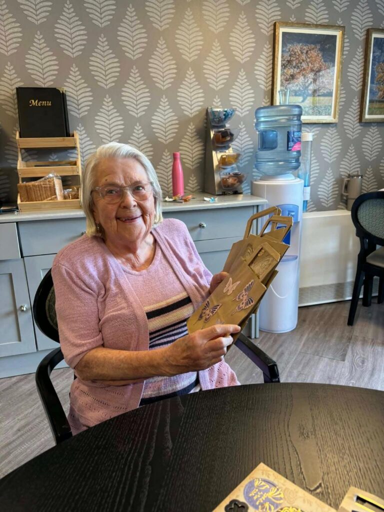 elderly woman smiling with homemade gift bag
