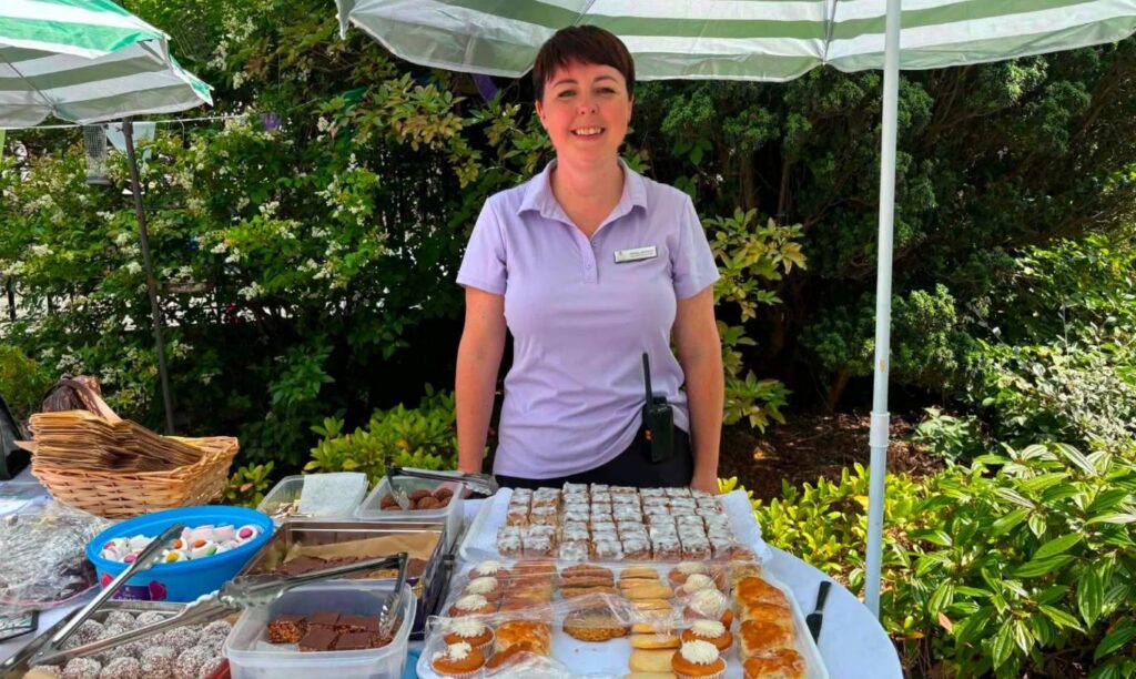 nurse selling cakes at summer fete