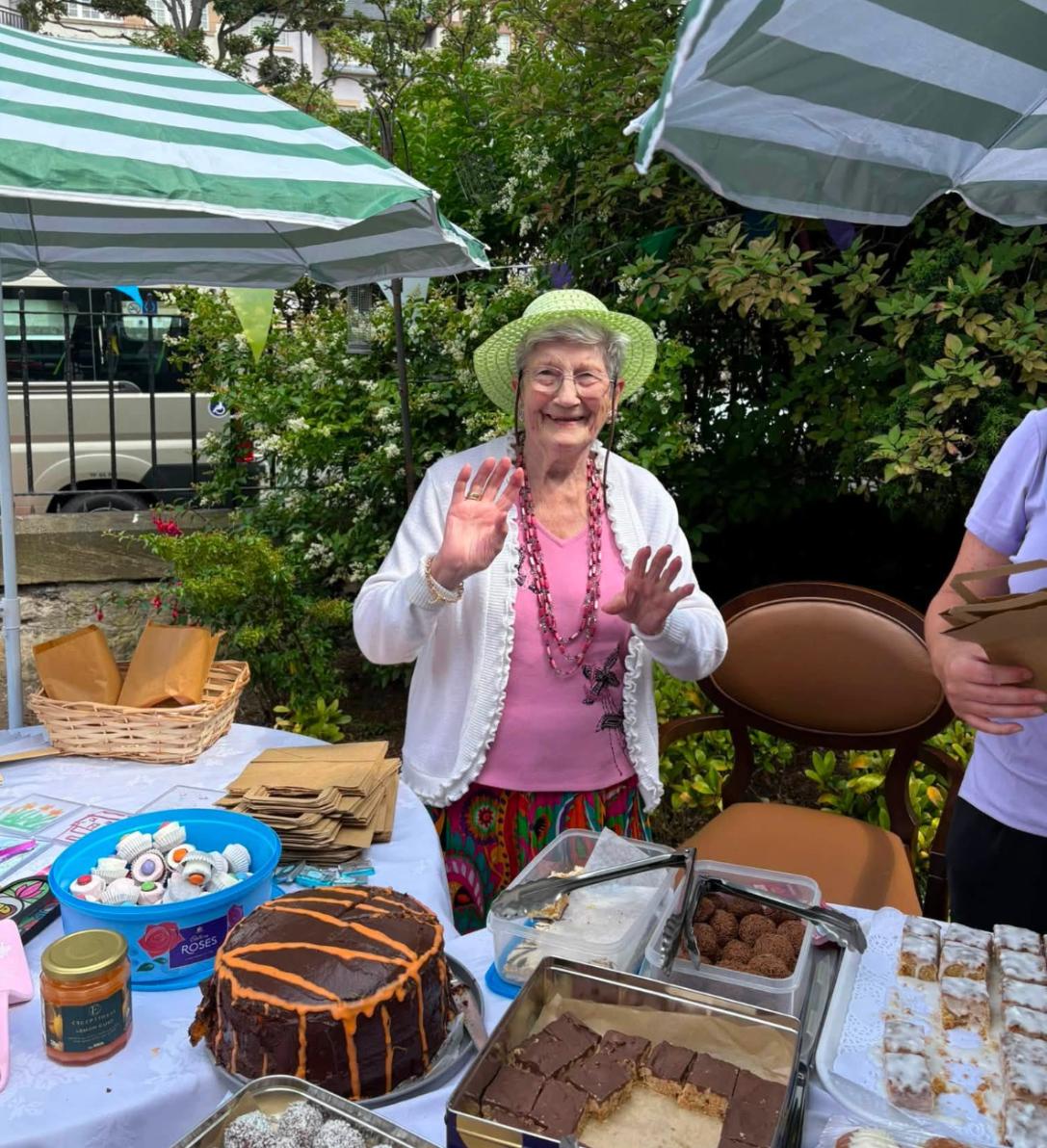 resident with cakes at summer fete