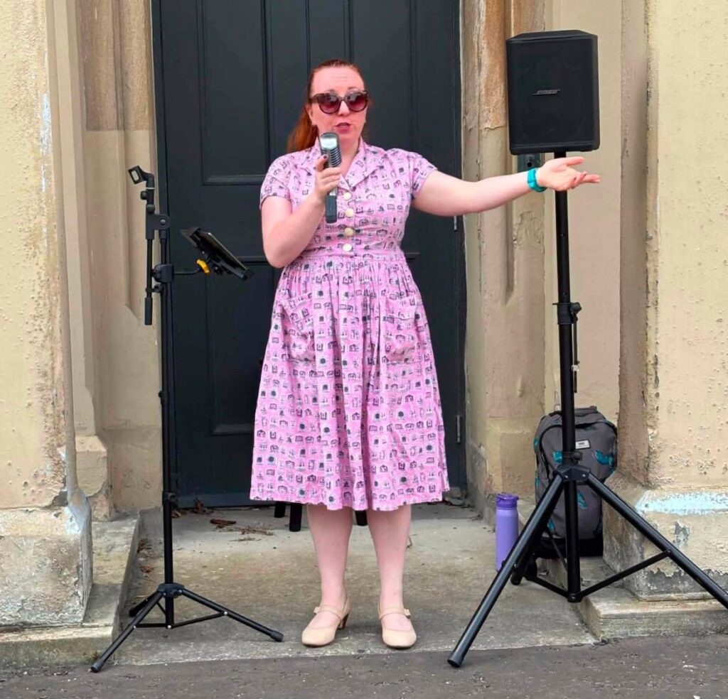 a singer wearing a pink dress with a mic
