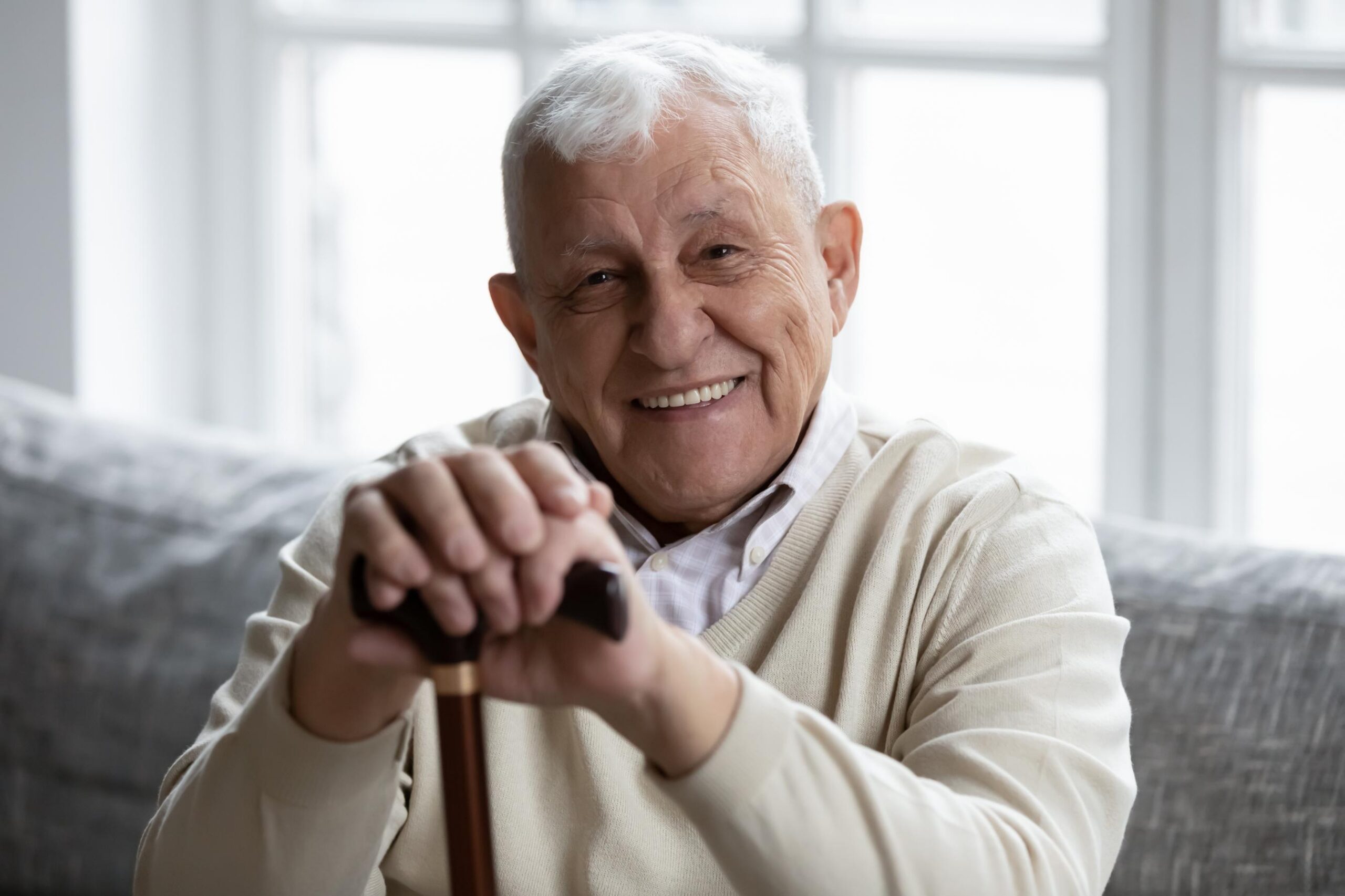 elderly man smiling with a walking aid