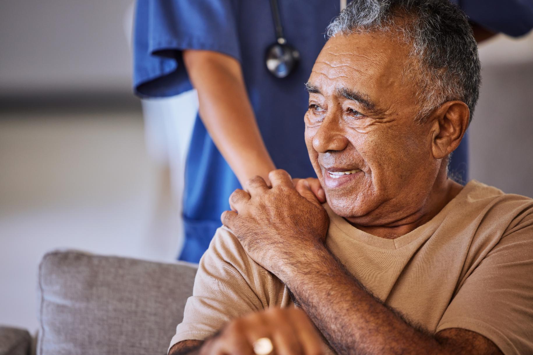 nurse with hand on resident's shoulder
